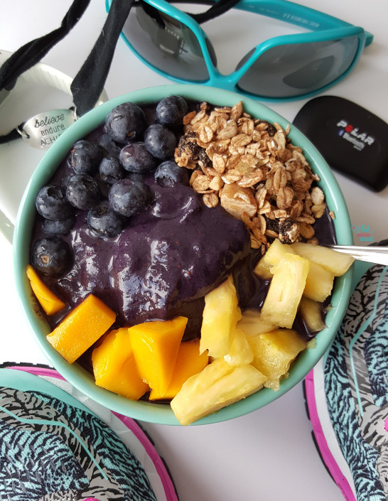 Acai Protein Smoothie Bowl made with vanilla protein, all acai juice, bananas, and blueberries. Topped with fresh blueberries, mango, pineapple, and muesli. (vegan and gluten free)