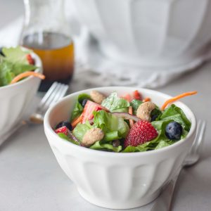 Simple and delicious salad packed with fresh sweet berries on a bed of romaine, carrots, and red onion dressed with a basic balsamic vinaigrette and topped with nuts. Great for lunch, dinner as a main or side, or your next get together for sharing. Naturally gluten free and vegan.