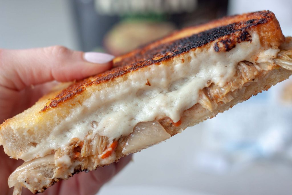 Holding a sourdough grilled cheese sandwich with kimchi