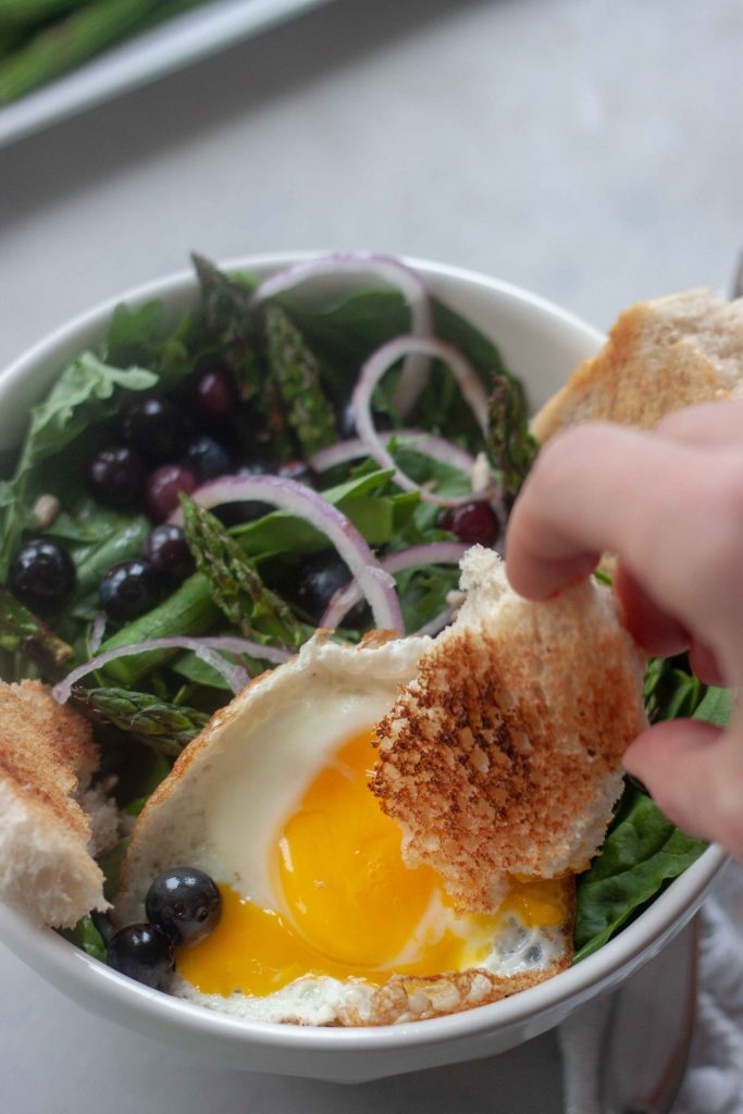 Dipping sourdough bread in yolk Pickled Blueberry Breakfast Salad