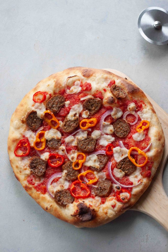 sausage pizza on wood board