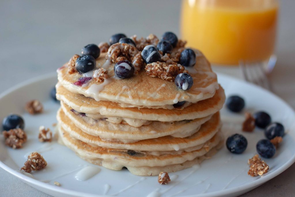 Plate of Blueberry Streusel Pancakes and glass of orange juice.