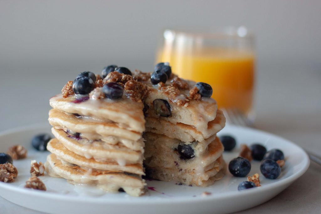 Plate of Blueberry Streusel Pancakes and glass of orange juice.