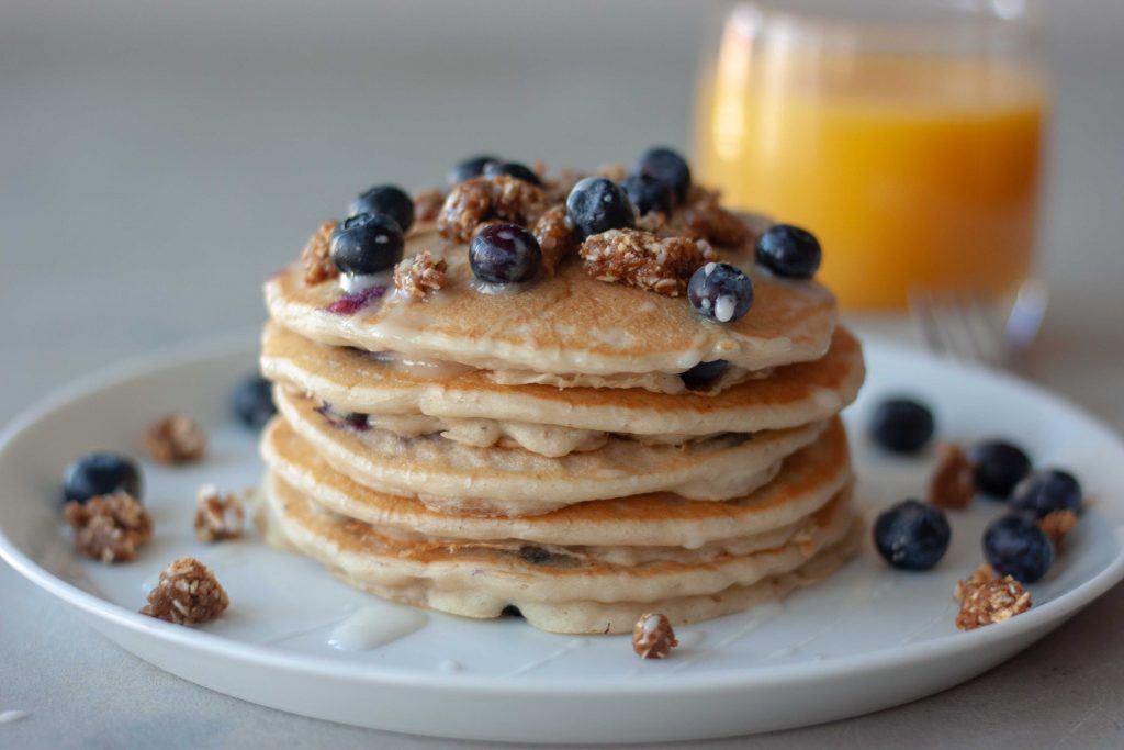 Plate of Blueberry Streusel Pancakes and glass of orange juice.