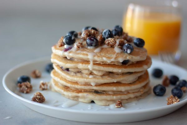 Stack of Blueberry Streusel Pancakes and glass of orange juice.