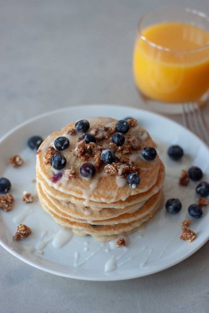 Plate of Blueberry Streusel Pancakes and glass of orange juice.