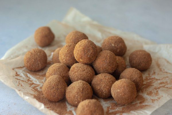 Pile of Cinnamon Sweet Potato No Bake Donut Holes and cinnamon sugar