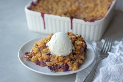 Piece of Sweet Corn Blueberry Crisp topped with ice cream