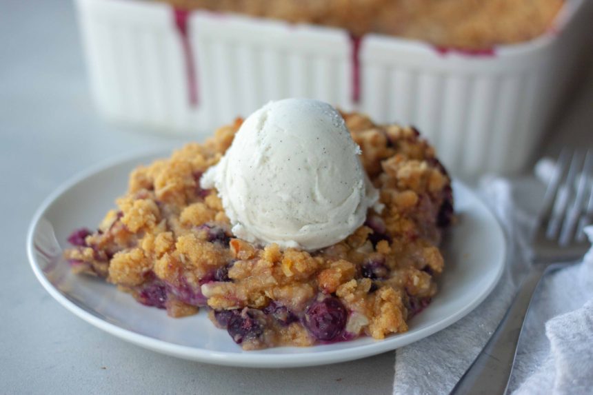 Piece of Sweet Corn Blueberry Crisp topped with ice cream