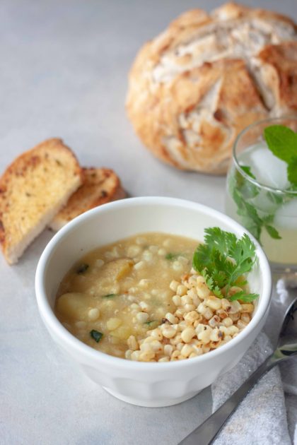 Bowl of Spicy Sweet Corn Soup with Sautéed Chili Lime Corn with loaf of bread