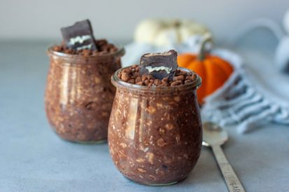 Two Overnight Oat Graveyard Cups with mini pumpkins and spoon