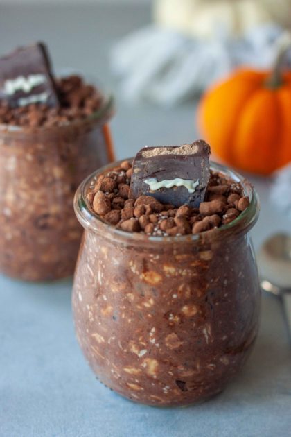 Two Overnight Oat Graveyard Cups with mini pumpkins and spoon