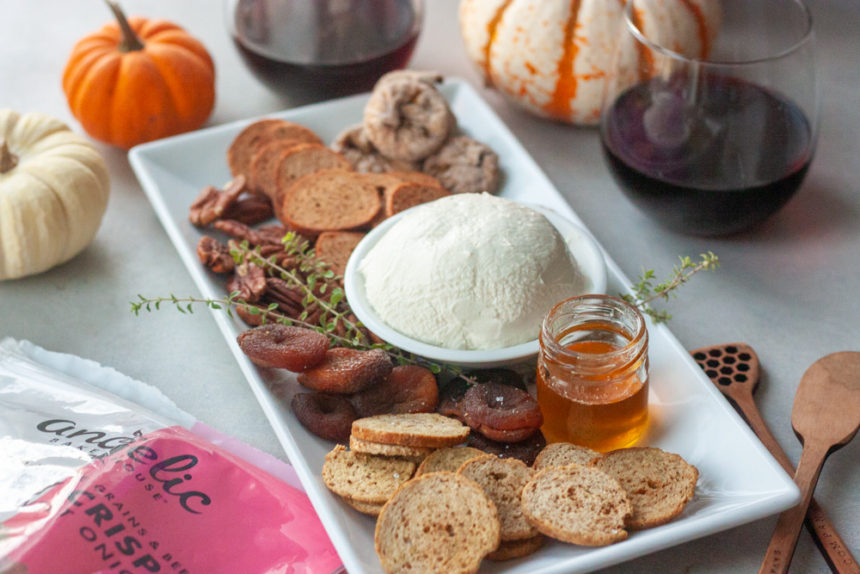 Charcuterie board, Angelic Bakehouse Sprouted Crisps, pumpkins, wine in 2 glasses, cheese, figs, honey