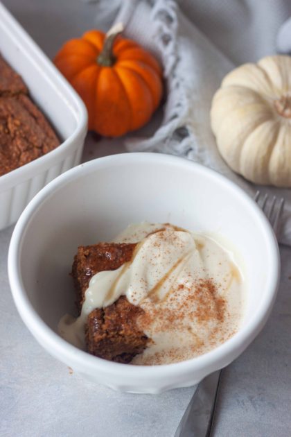 Pumpkin Breakfast Cake in a bowl with yogurt and honey.