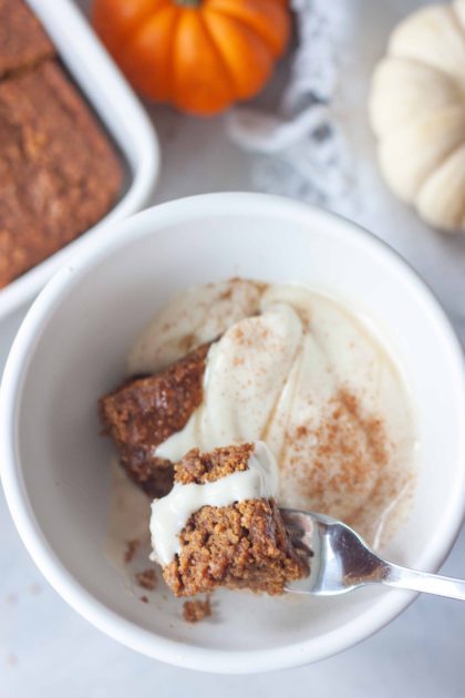 Pumpkin Breakfast Cake in a bowl with yogurt and honey.