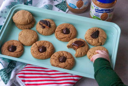 Baby grabbing a cookie from a tray